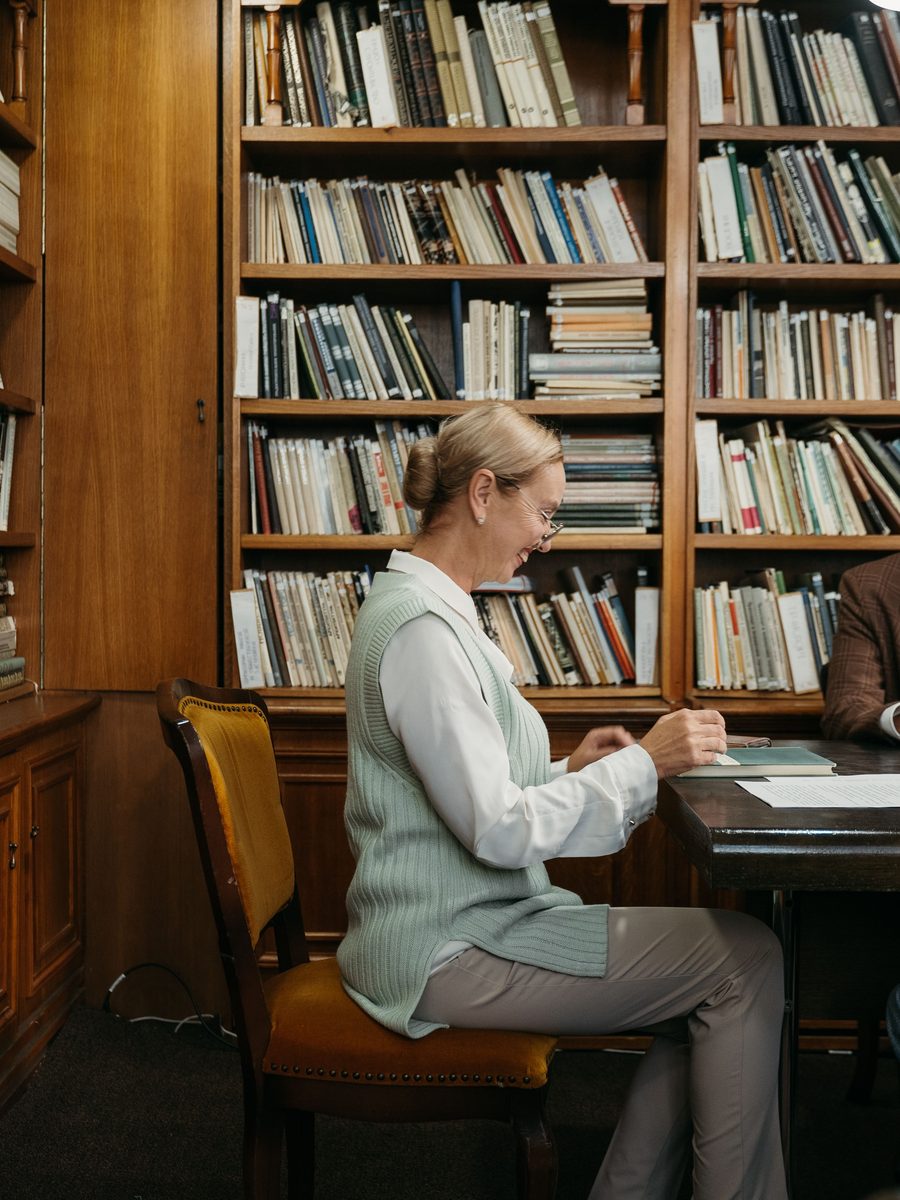 Een directeur alleen aan een bureau tussen boeken